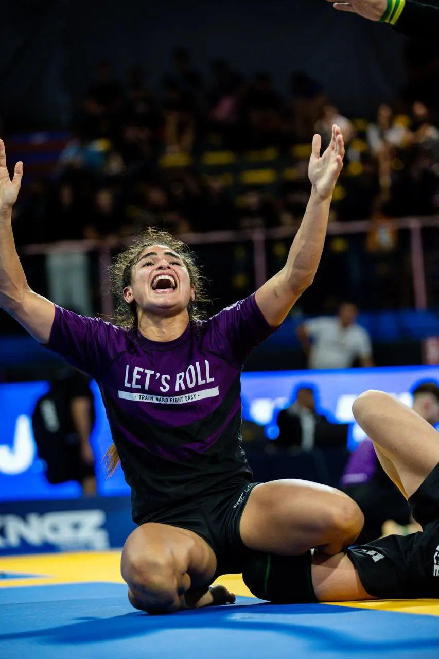 Javiera Fuentes celebrando de rodillas en el tatami, con los brazos en alto
