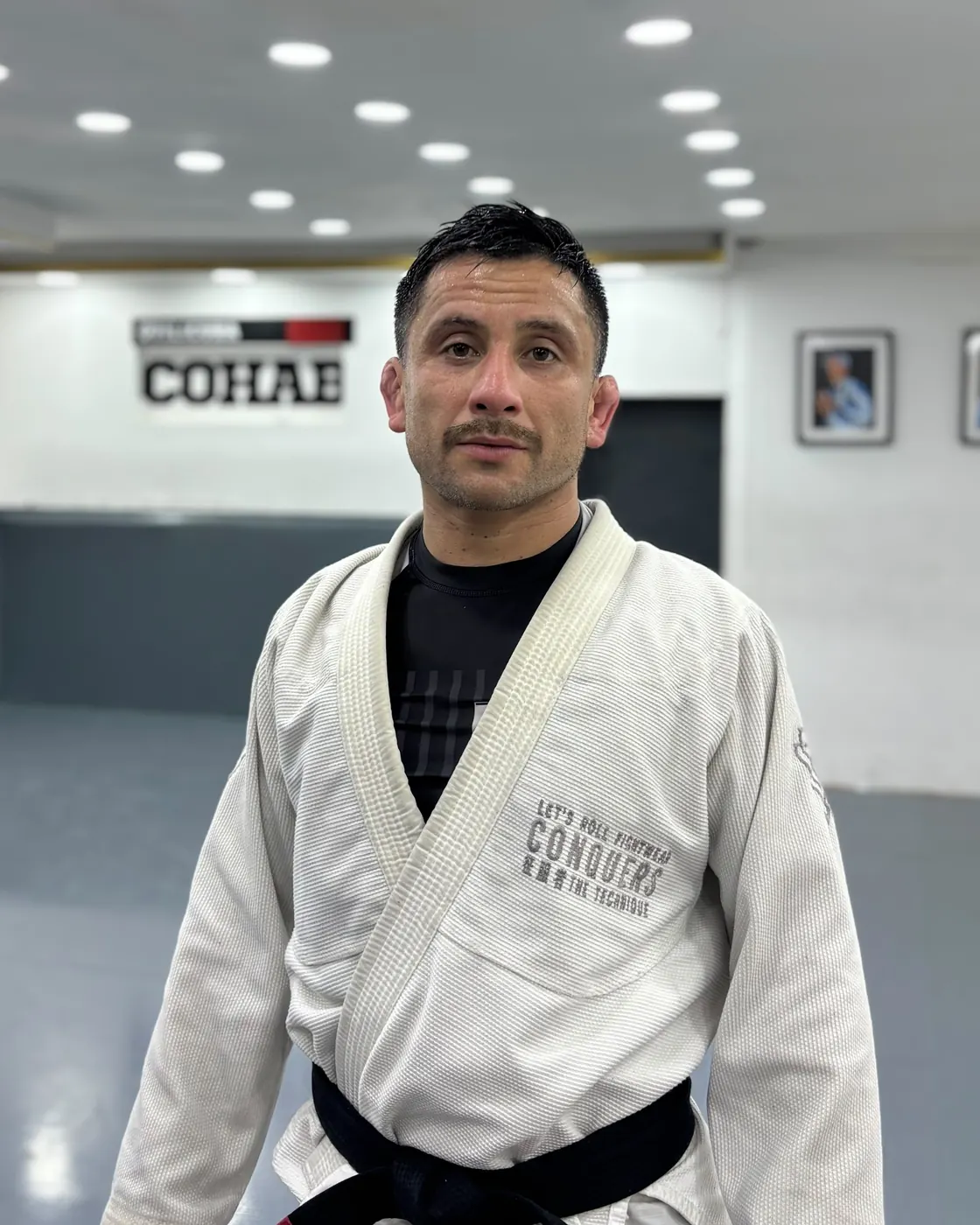 Mestre Matías Gálvez, profesor principal de Cohab Quilicura, con kimono blanco y cinturón negro en la academia